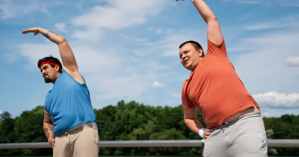 Two men stretching outdoors to fight signs your body is aging faster than you are
