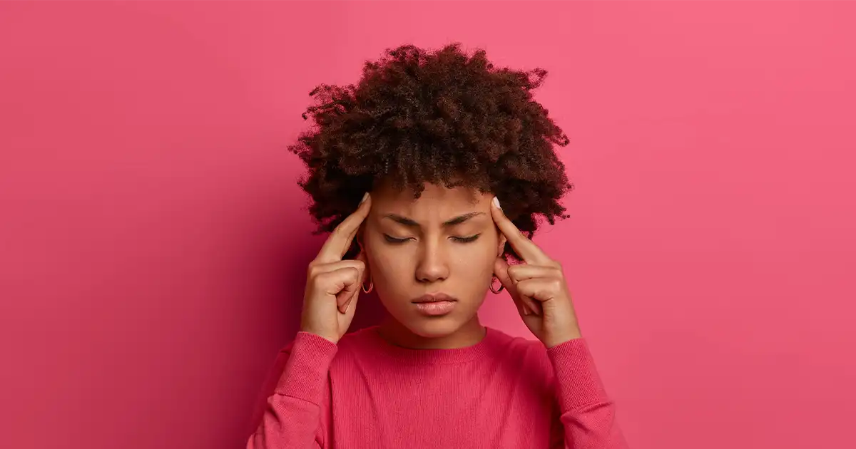 Woman pressing temples in concentration, struggling with hormone brain fog and memory problems