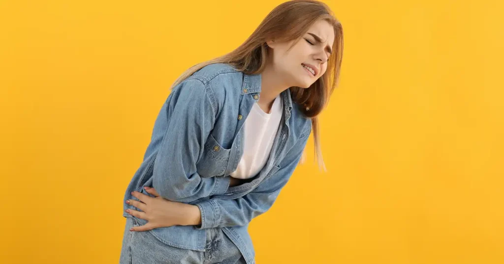 Woman holding stomach in pain from heavy painful period and hormonal cramps