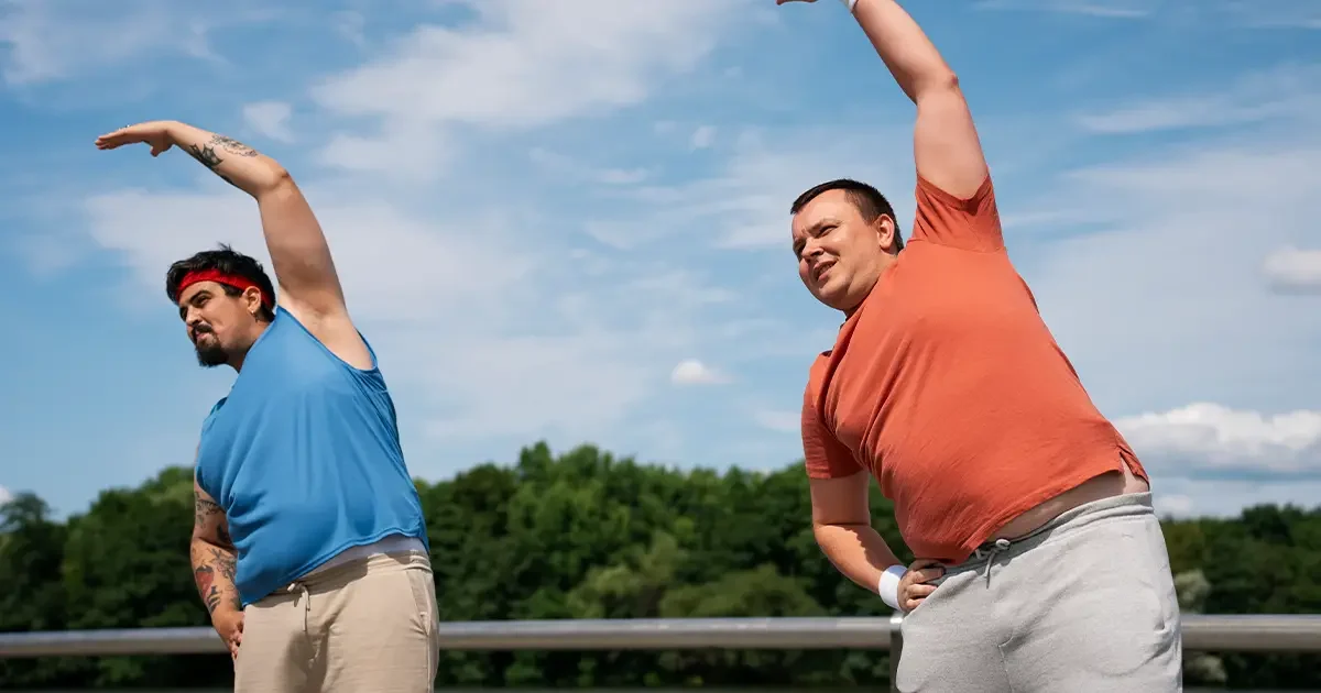 Two men stretching outdoors to fight signs your body is aging faster than you are